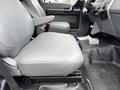 The interior of a 2011 Ford F-650 featuring a gray upholstered driver's seat and a passenger seat with armrests and a simple dashboard setup