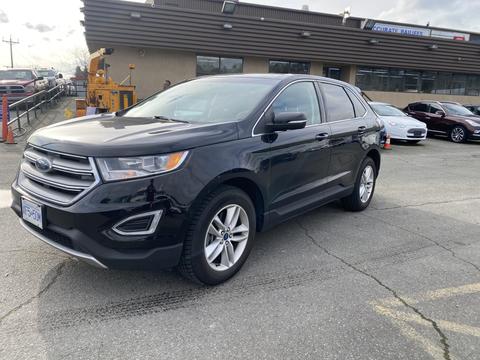 A black 2017 Ford Edge is parked with its left side facing the viewer showcasing its sleek design and modern features