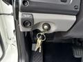The interior view of a 2021 Freightliner M2 106 showing the park brake release lever and a set of keys hanging from the ignition switch