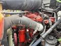 Close-up of the engine compartment of a 2011 Ford F-650 showing various hoses and components including a red engine part and attached filters
