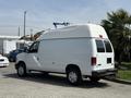 A white 2008 Ford Econoline van with a high roof and rear doors parked on a concrete surface