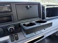 Interior view of a 2015 Mitsubishi Fuso FE featuring a dashboard with a radio and a cup holder compartment