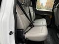 The interior of a 2022 Ford F-550 showing the back seat with light gray leather upholstery and seat belts visible