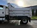 A white 2011 International WorkStar truck with a dump bed and a side ladder visible on the truck's body