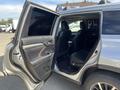 A 2018 Toyota Highlander with an open rear door showcasing the interior seating and floor mats
