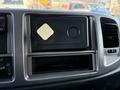 A black dashboard panel of a 2015 Hino 358 with a card slot and a white square object placed on it
