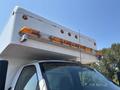 A 2007 GMC C4500 TopKick with a large white box truck body and multiple amber clearance lights on top of the cab