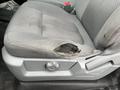 A worn driver's seat in a 2013 Ford F-150 showing a tear in the fabric and exposed padding on the side of the seat