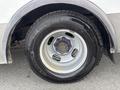 A close-up of the wheel and tire of a 2018 Chevrolet Express featuring a silver rim with blue lug nuts and a Michelin Agilis CrossClimate tire