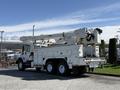 A 2008 International 7500 bucket truck with an extendable boom and a utility body is parked with its safety lights on