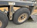 Close-up of the tire and wheel assembly of a 2013 JLG Industries 1014 showcasing the tread and metallic rim with visible wear and rust