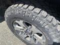 Close-up of a 2014 Ford F-150 tire featuring a rugged tread pattern and a dark alloy wheel with a multi-spoke design