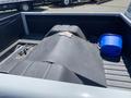 A 1962 Ford truck bed with a black cover over the cargo area a blue bucket and a cloth resting on the cover