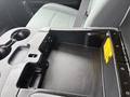 The interior console of a 2016 RAM 1500 featuring cup holders a storage compartment and USB ports