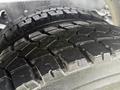 A close-up view of a tire with a rugged tread pattern showcasing deep grooves and textures designed for traction on various surfaces