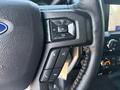 Close-up of the steering wheel controls of a 2019 Ford F-150 featuring audio volume buttons and phone control functions
