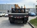 A 2011 International 4300 truck with a flatbed and a mounted crane at the rear