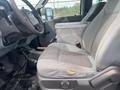 A 2014 Ford F-350 SD featuring a gray cloth driver's seat with a storage box in between the seats and a steering wheel visible in the foreground