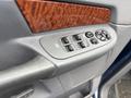 Interior door panel of a 2006 Dodge Ram 2500 with wood grain accents and controls for windows and locks