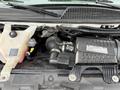 Close-up of the engine compartment of a 2020 Chevrolet Express featuring the Vortec engine and various components including hoses and a coolant reservoir