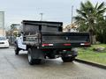 A 2017 Ford F-450 Super Duty truck with a flatbed and a black dump bed is shown from the rear side