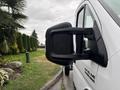 A close-up view of the side mirror of a 2023 RAM Promaster 3500 vehicle showing rain droplets on the surface