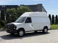 A white 2008 Ford Econoline van with a high roof parked on a paved surface