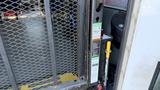 A 2021 Ford Transit with a metal gate and safety warning labels on the side
