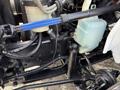 Close-up view of the engine compartment components of a 2011 International 4300 including tubes hoses and a coolant reservoir