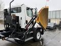 A 2016 Freightliner 108SD truck with a snow plow attached is positioned in a parking area facing left with a hydraulic lift system visible behind the cab