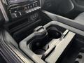 Close-up of the center console of a 2021 RAM 1500 showing a dual cup holder with a removable divider and various controls for media and climate settings