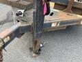 A 2013 JLG Industries Flat Deck Trailer with a sturdy metal frame and a prominent hitch connection featuring a support leg and a visible safety sticker