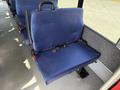 A blue fabric bus seat with a safety belt attached, mounted on a metal frame inside a vehicle