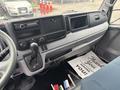 Interior of a 2015 Mitsubishi Fuso FE160 showing the dashboard with controls and gear shift alongside a thank you note on the floor mat