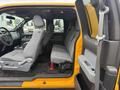 A 2014 Ford F-150 with a spacious gray interior featuring front bucket seats and a rear bench seat with a simple layout and a console in the front