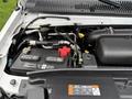 A close-up view of the engine compartment of a 2022 Ford E-450 showing the battery and various engine components
