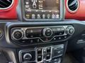 Dashboard controls of a 2021 Jeep Wrangler featuring climate settings and a multimedia display