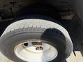 A close-up of a tire and rim from a 2012 Ford Econoline showing tread patterns and the Bridgestone branding on the tire