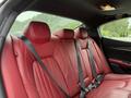 Red leather interior of a 2016 Maserati Ghibli showing rear seats and seatbelts