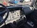 Interior dashboard of a 2005 Freightliner M2 106 featuring controls gauges and a radio with various buttons and switches
