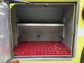 Interior of a 1995 Freightliner FL086 cargo compartment with a red grated floor and metallic shelves installed on the walls