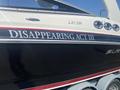 A 2013 Larson 238 boat with a black hull and red detailing featuring the name "DISAPPEARING ACT III" prominently displayed on the side