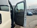 A 2021 Chevrolet Express van with the passenger side door open showing the interior panel and door handle