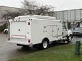 A 2014 International TerraStar truck with a white exterior featuring multiple storage compartments and a flatbed design