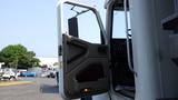 A 2003 International 5600i truck with its driver's side door open showing the interior controls and seat