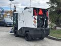A 2019 Madvac LS175 street cleaning machine with a compact design and large rear vacuum attachment equipped with warning lights and a side broom