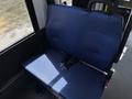A blue upholstered seat with seatbelt restraints in a vehicle interior