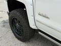 2017 Chevrolet Silverado 1500 with a mud tire and a black wheel showing the High Country emblem on the side