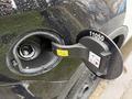 A close-up of the fuel cap on a 2019 Ford Explorer showing the fuel nozzle opening with labels and instructions on the cap