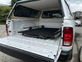 A white 2013 RAM 1500 truck with its tailgate down showing an open bed and a pull-out cargo management system